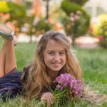 portrait-beautiful-girl-outside-lying-smiling-while-holding-flowers-black-t-shirt-daytime_176474-6782